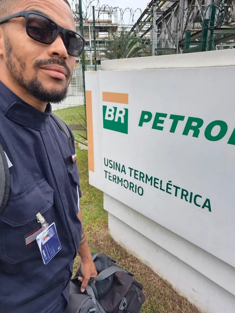 Instrutor da Martins ao lado da placa da Usina Termelétrica TermoRio